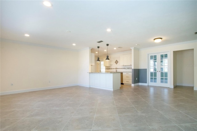 unfurnished living room featuring ornamental molding, french doors, and baseboards