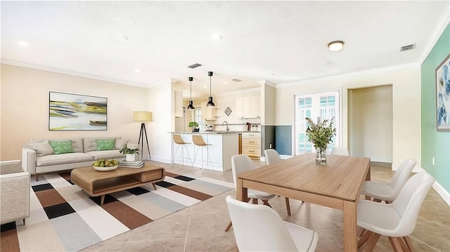 living room featuring ornamental molding, visible vents, and baseboards