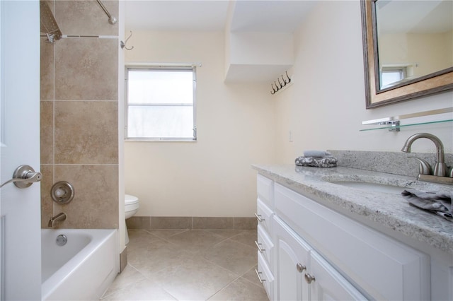 full bath featuring tile patterned flooring, toilet, vanity, baseboards, and washtub / shower combination