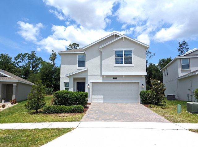 view of front of property with cooling unit, a garage, and a front lawn