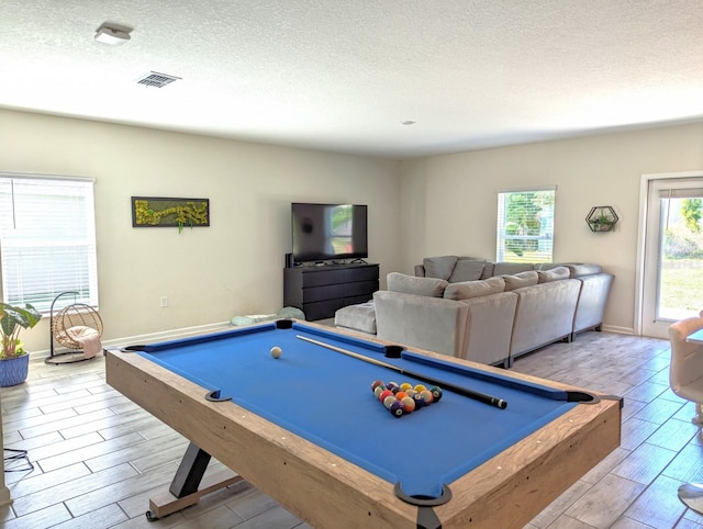 rec room with a textured ceiling, billiards, and light hardwood / wood-style flooring