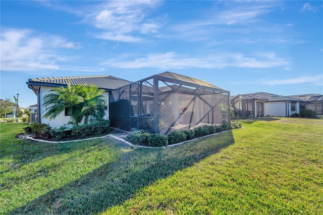 exterior space featuring a lanai and a lawn