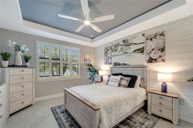 bedroom with ceiling fan and a tray ceiling