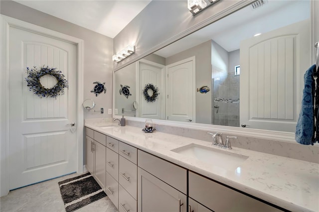 bathroom with a tile shower, vanity, and tile patterned flooring