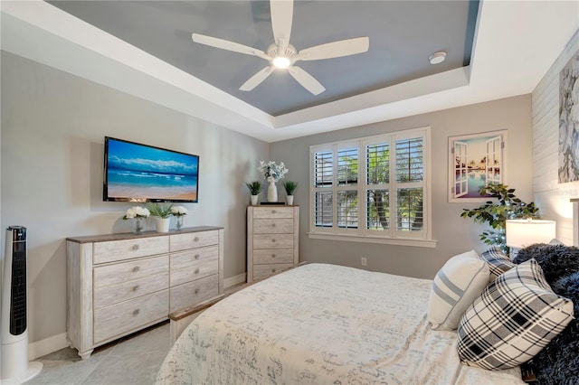 bedroom with ceiling fan and a tray ceiling