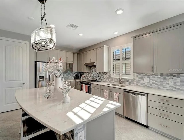 kitchen with gray cabinets, appliances with stainless steel finishes, and a center island