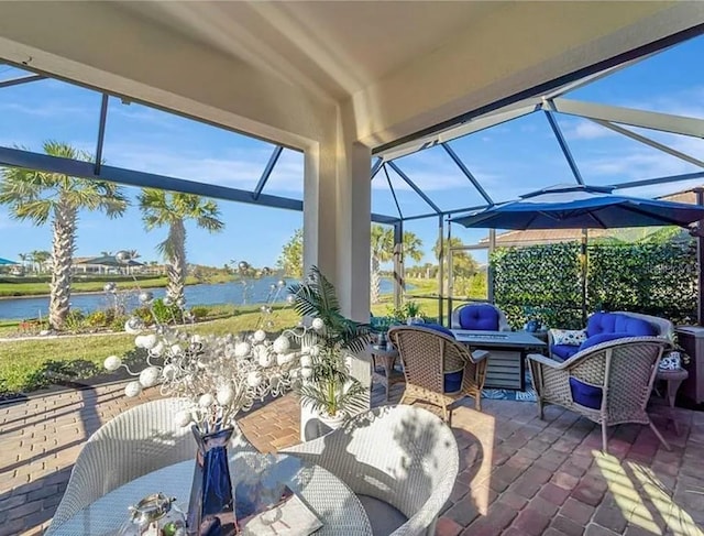 view of patio / terrace with an outdoor living space, a water view, and a lanai