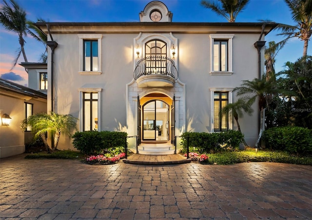 view of front of house with french doors and a balcony