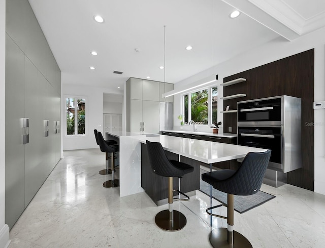 kitchen featuring a healthy amount of sunlight, a breakfast bar, a spacious island, and black double oven