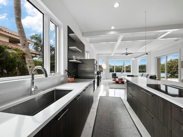 kitchen featuring plenty of natural light, coffered ceiling, and sink