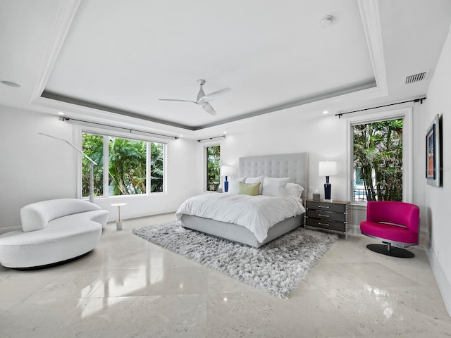 bedroom featuring a raised ceiling, multiple windows, and ceiling fan