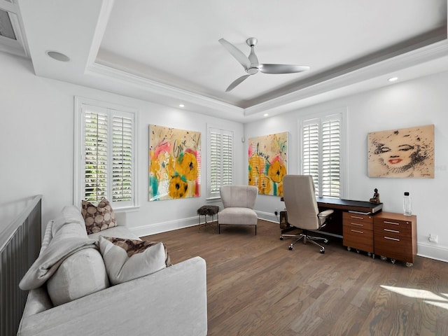 office with a tray ceiling, plenty of natural light, and ceiling fan