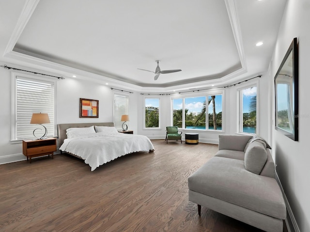 bedroom with dark hardwood / wood-style flooring, a raised ceiling, ceiling fan, and ornamental molding