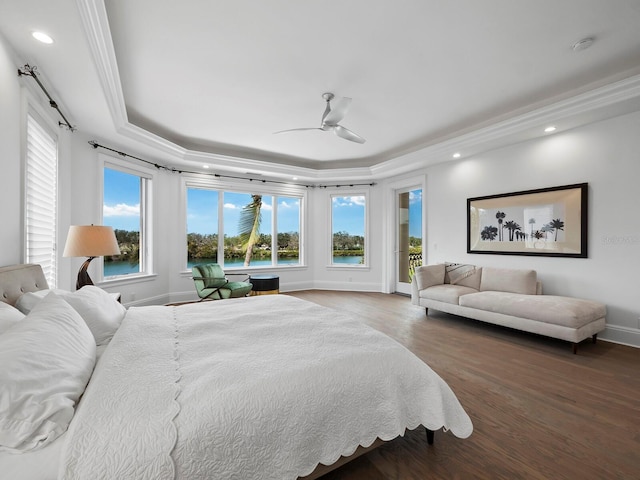 bedroom with hardwood / wood-style flooring, a raised ceiling, ceiling fan, and ornamental molding