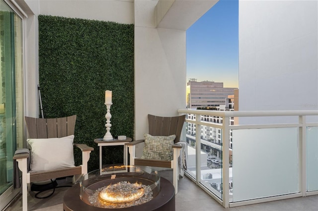 balcony at dusk featuring a fire pit