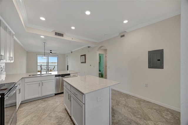 kitchen with kitchen peninsula, appliances with stainless steel finishes, sink, white cabinets, and a kitchen island