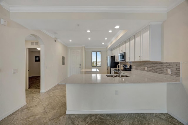 kitchen with crown molding, light stone countertops, appliances with stainless steel finishes, white cabinetry, and kitchen peninsula