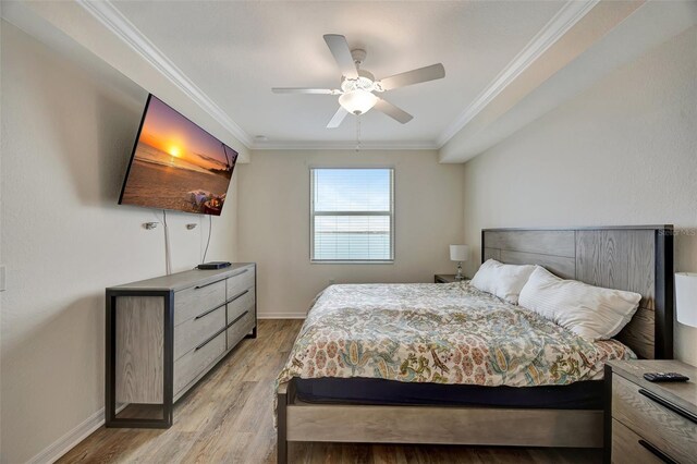 bedroom with ceiling fan, crown molding, and light wood-type flooring