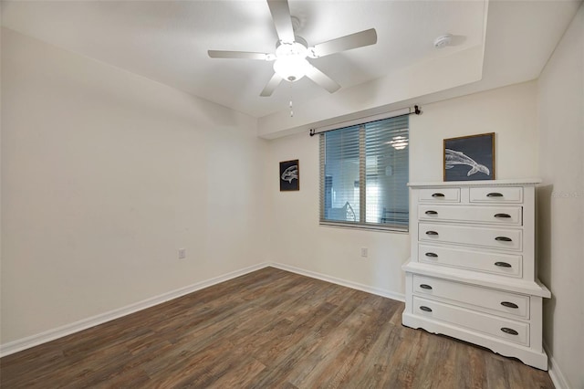 unfurnished bedroom with ceiling fan and dark wood-type flooring