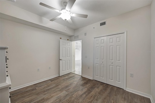 unfurnished bedroom with a closet, ceiling fan, and dark hardwood / wood-style flooring