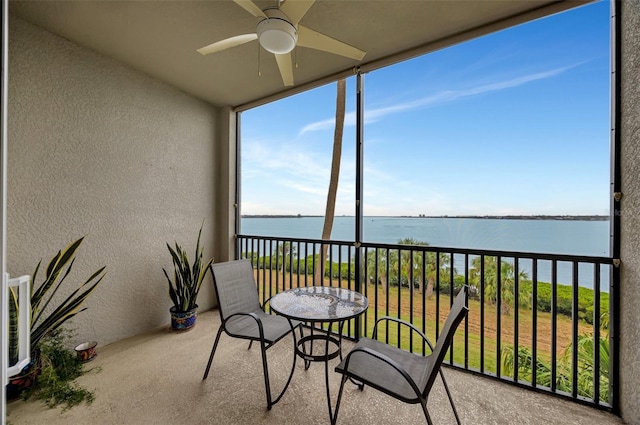 sunroom / solarium featuring ceiling fan and a water view