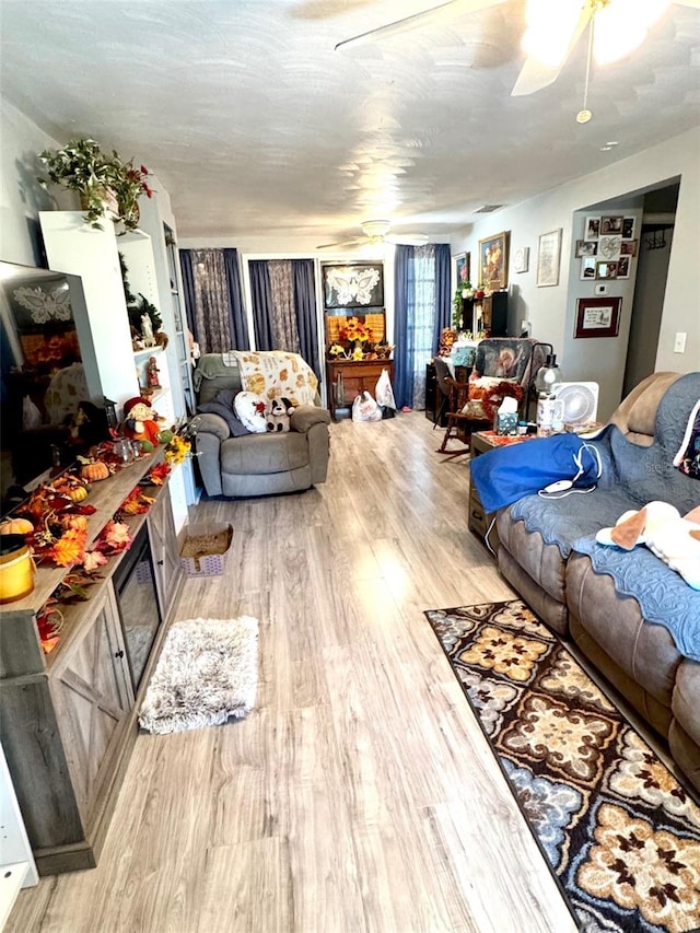 living room featuring ceiling fan and light wood-type flooring