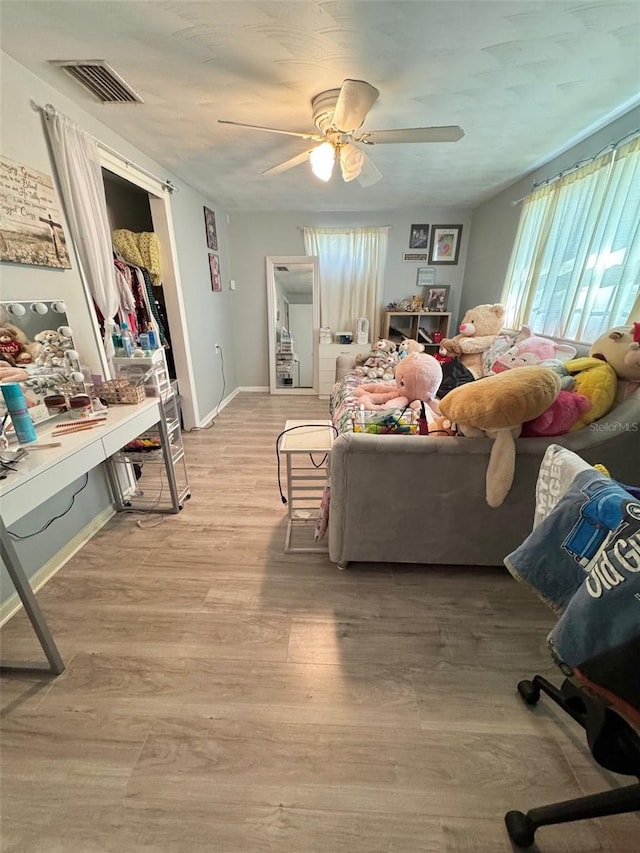 living room featuring ceiling fan and light hardwood / wood-style floors