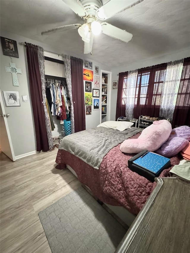 bedroom featuring hardwood / wood-style floors, ceiling fan, and a closet