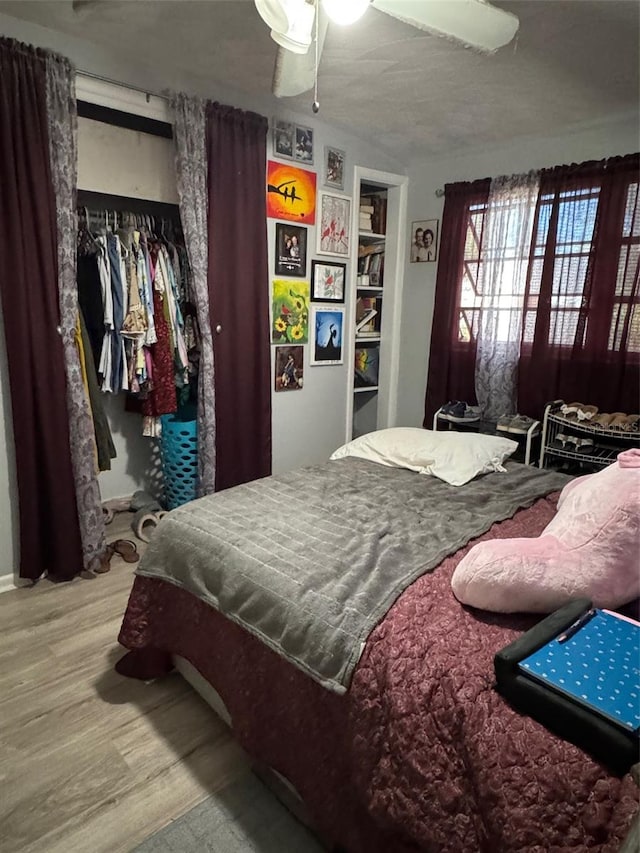 bedroom featuring ceiling fan, a closet, light hardwood / wood-style floors, and a textured ceiling