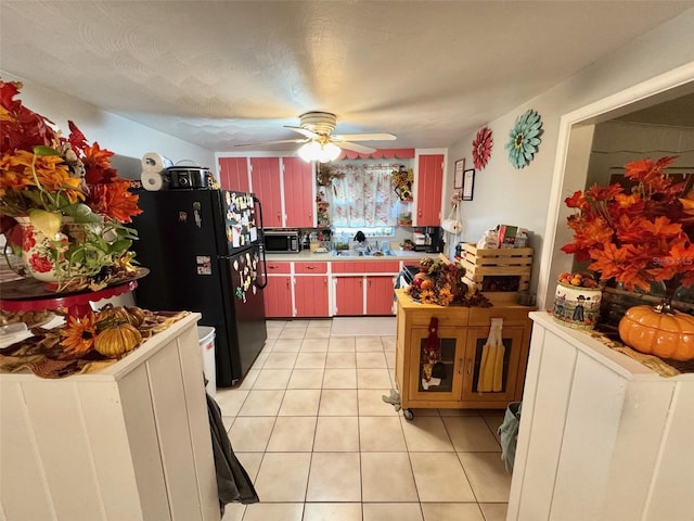 kitchen with black fridge, light tile patterned floors, a textured ceiling, and ceiling fan