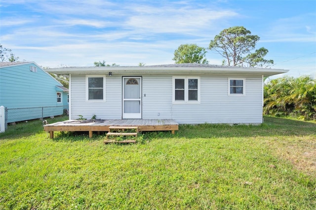 rear view of property with a lawn and a wooden deck