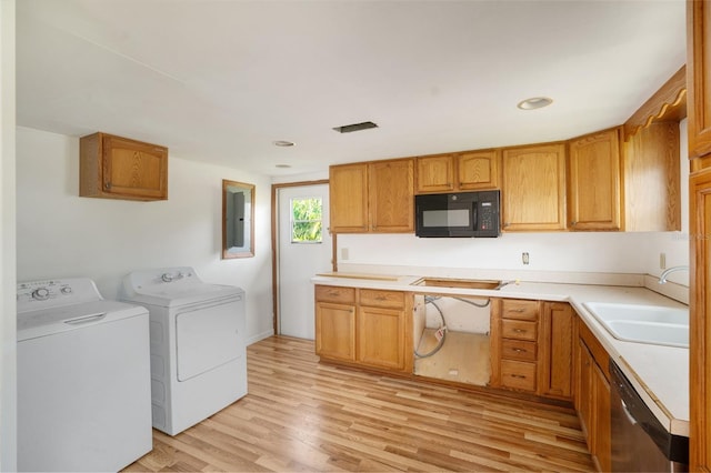 kitchen with dishwasher, electric panel, sink, separate washer and dryer, and light hardwood / wood-style floors