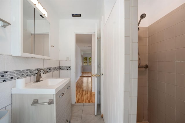 bathroom featuring vanity, tile walls, and hardwood / wood-style flooring