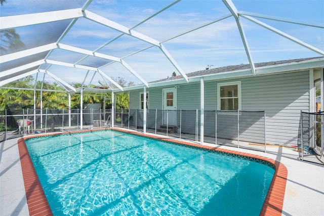 view of swimming pool featuring glass enclosure and a patio area