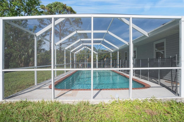 view of swimming pool featuring glass enclosure