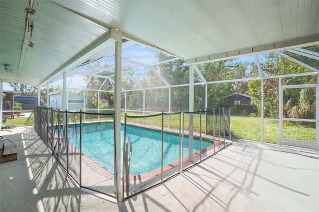 view of pool featuring a patio, glass enclosure, and a lawn