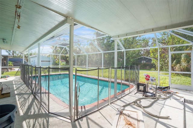 view of swimming pool with a lanai, a patio area, and a lawn