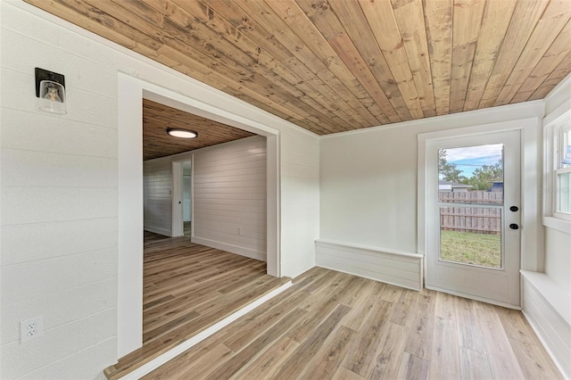 spare room featuring hardwood / wood-style flooring, wooden ceiling, and wooden walls