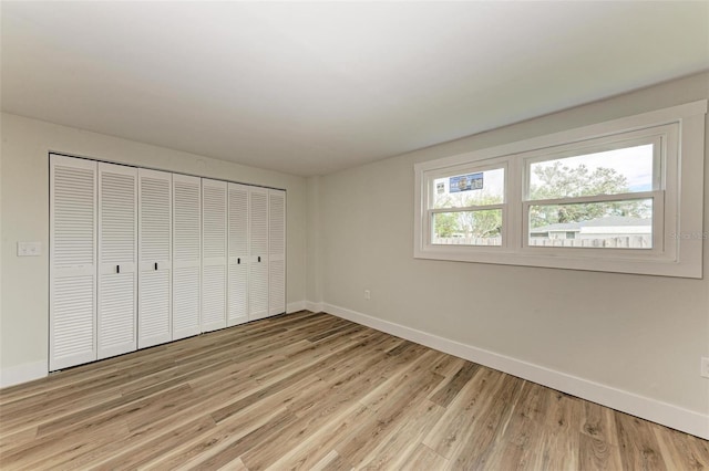 unfurnished bedroom featuring light wood-type flooring and a closet