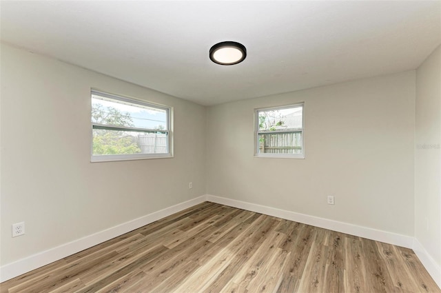 unfurnished room featuring light hardwood / wood-style floors and a healthy amount of sunlight