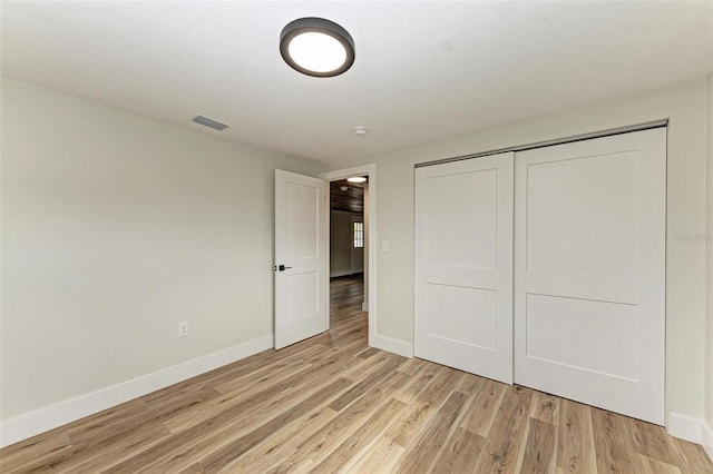 unfurnished bedroom featuring a closet and light wood-type flooring