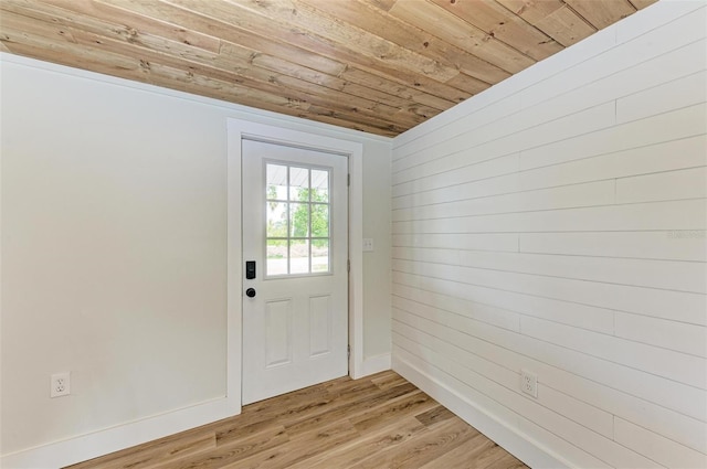 doorway to outside featuring wooden ceiling, wooden walls, and light hardwood / wood-style flooring