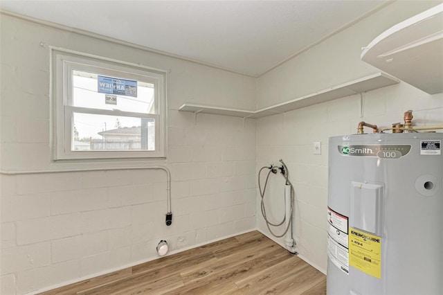 washroom featuring hardwood / wood-style flooring, hookup for a washing machine, and water heater