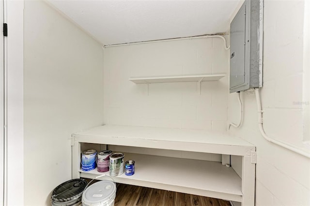 laundry area featuring electric panel and dark hardwood / wood-style floors