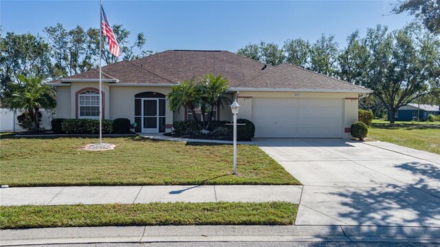 ranch-style home featuring a garage and a front lawn