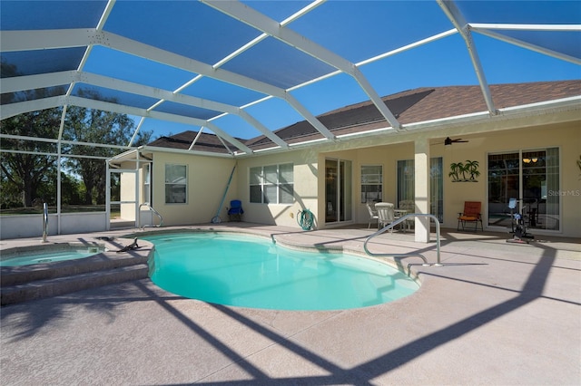 view of swimming pool with an in ground hot tub, a patio, glass enclosure, and ceiling fan