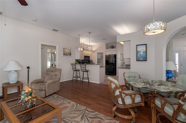 living room with ceiling fan, wood-type flooring, and a textured ceiling