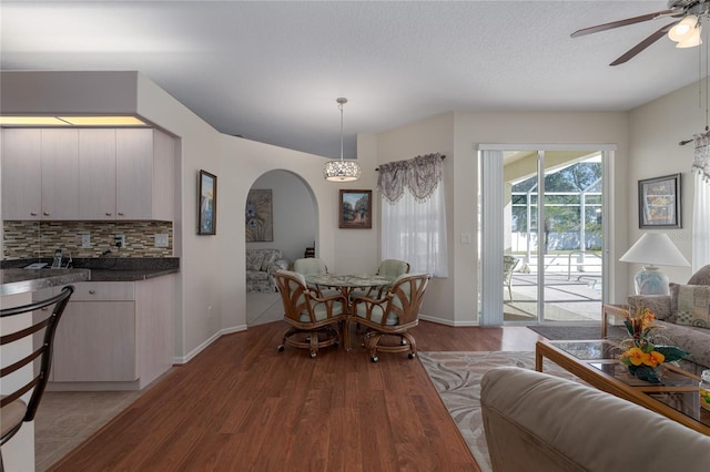 dining space with ceiling fan, a textured ceiling, and light hardwood / wood-style flooring