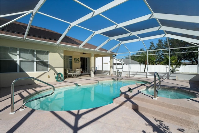 view of pool with glass enclosure, a jacuzzi, ceiling fan, and a patio