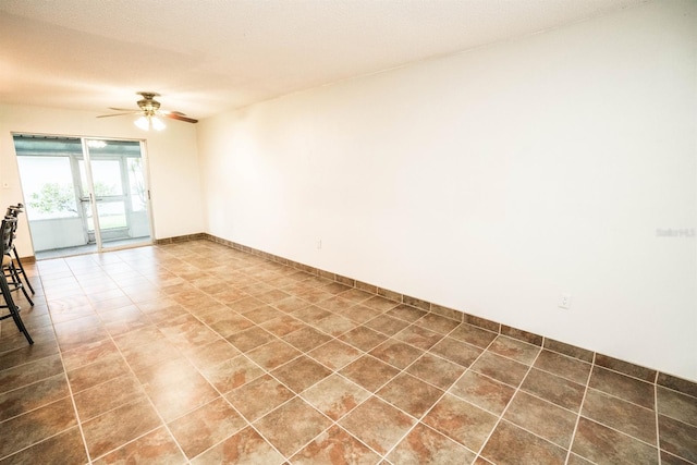 tiled empty room with ceiling fan and a textured ceiling